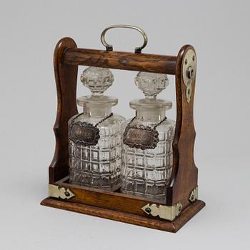 An oak, silver, silverplated and glass tantalus with lock. Second half of the 20th century.