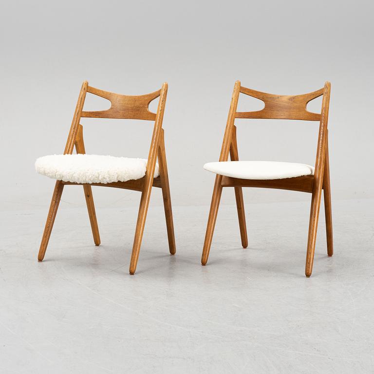 A set of six model CH 29 oak chairs by Hans J Wegner, two with leather upholstery and four with sheepskin.