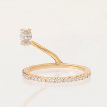 An 18K gold ring set with an oval cut and round brilliant cut diamonds by LWL Jewelry.