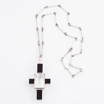 Wiwen Nilsson, hängsmycke i form av ett kors i sterlingsilver med fasettslipad bergkristall och onyx, Lund 1938.