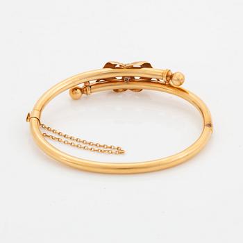 An 18K gold bangle set with a pearl.