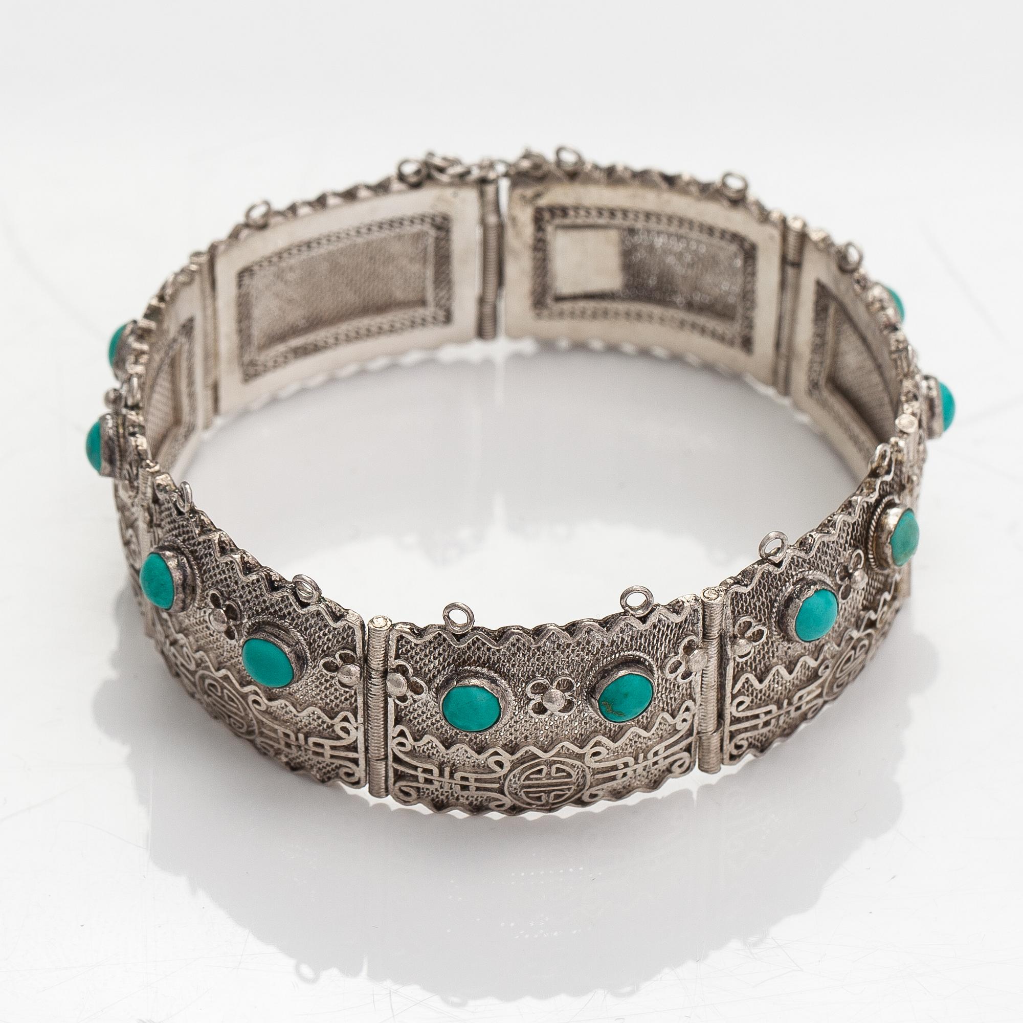 A silver bracelet and ring with turquoises. China.