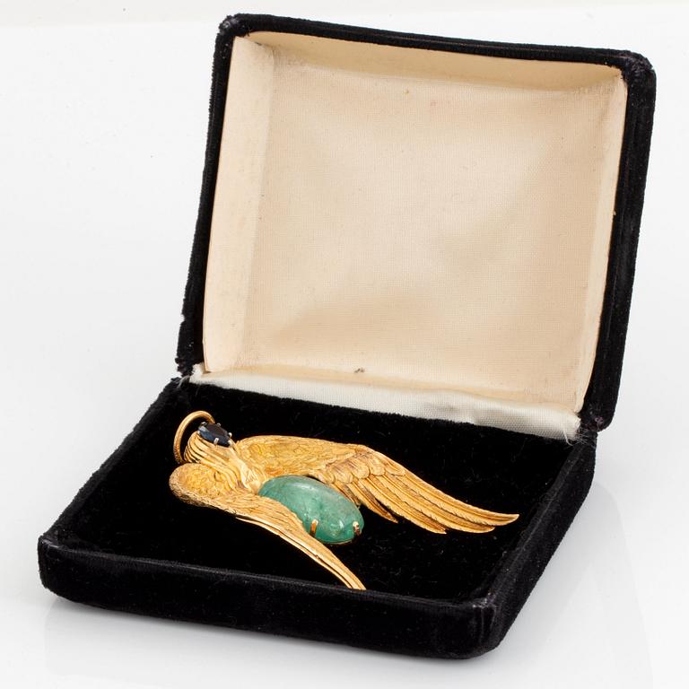 A 14K gold pendant by Salvador Dalí set with a cabochon-cut emerald and a faceted sapphire.