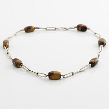 Birger Haglund, a silver and tiger's eye necklace.