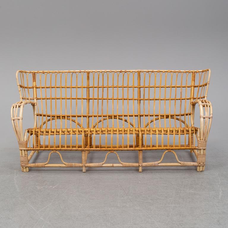 A rattan and glass table and a rattan sofa, second half of the 20th century.