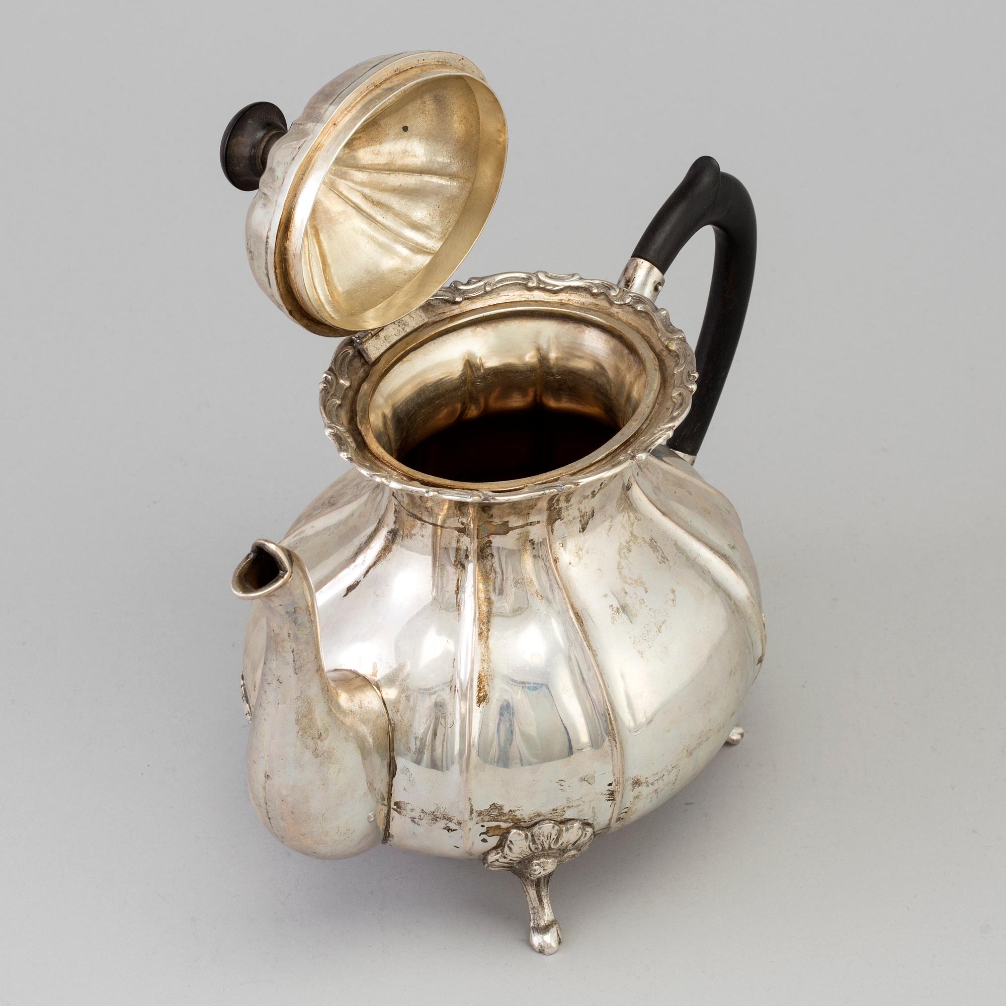A silver rococo style teapot.