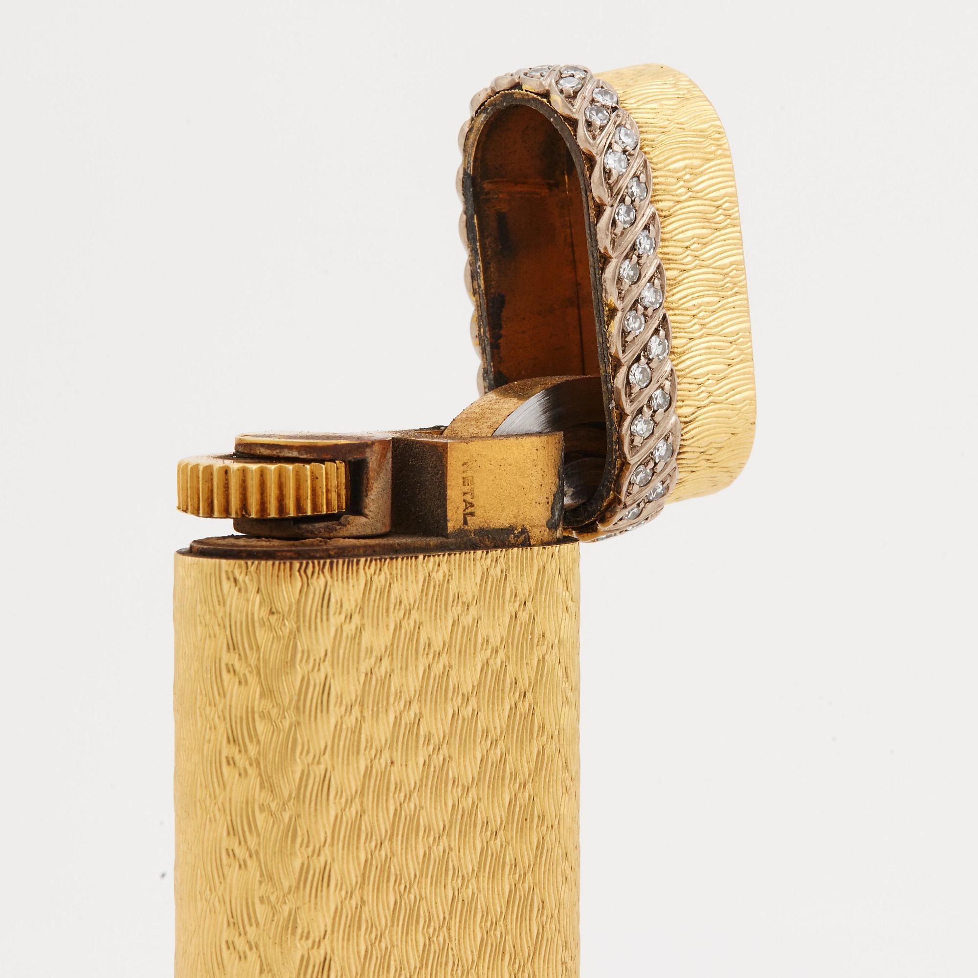 A cigarette lighter by Cartier set with single cut diamonds.