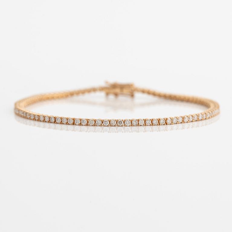 Tennis bracelet 14K gold with round brilliant-cut diamonds.