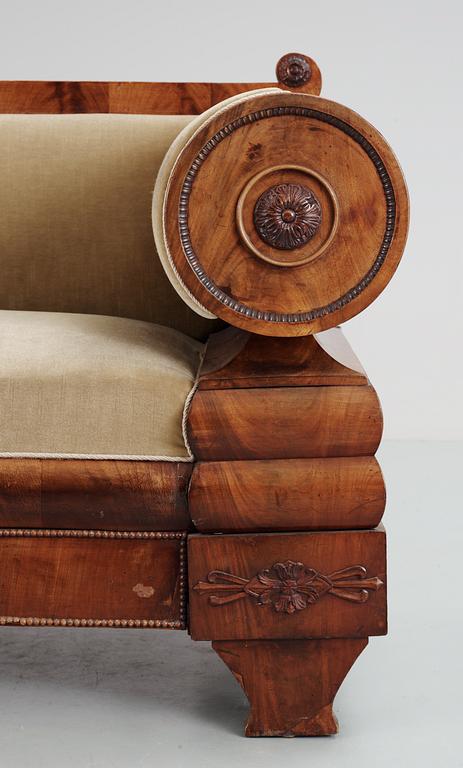 A mahogny veneer Empire sofa. 19th Century.
