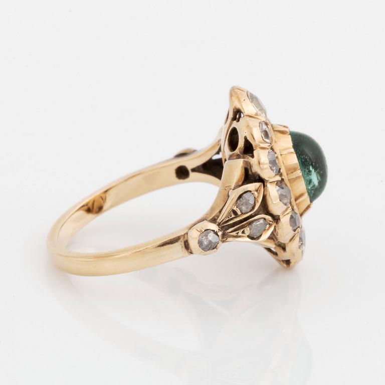 A 14K gold ring set with a cabochon-cut emerald and old-cut diamonds.