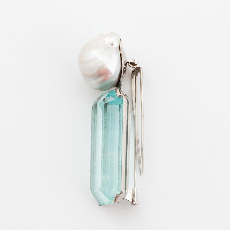 A Tina Karlsson a brooch in 18K white gold set with a large step-cut aquamarine and a cultured pearl.