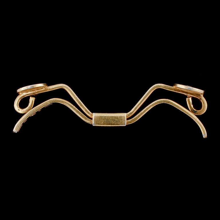 SPÄNNE, 18k guld med 2 briljantslipade diamanter, Nils Ahlström, Borås, 1953. Vikt 6 g.