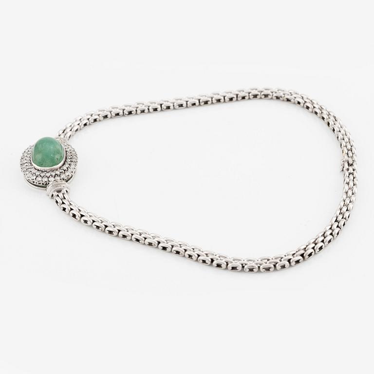 An 18K white gold necklace with a cabochon-cut emerald and round brilliant-cut diamonds.