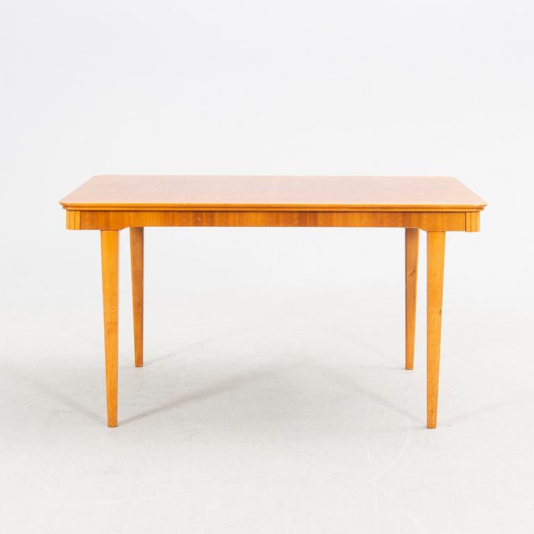 A 1940s mahogany and walnut dining table.