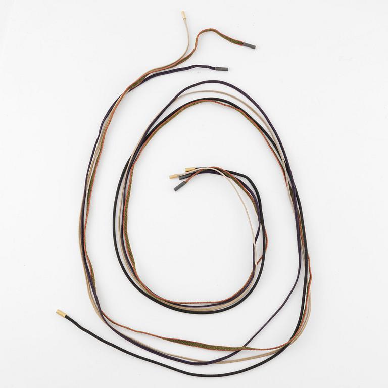 Ole Lynggaard fyra stycken halsband/remmar i textil samt guld och silver.