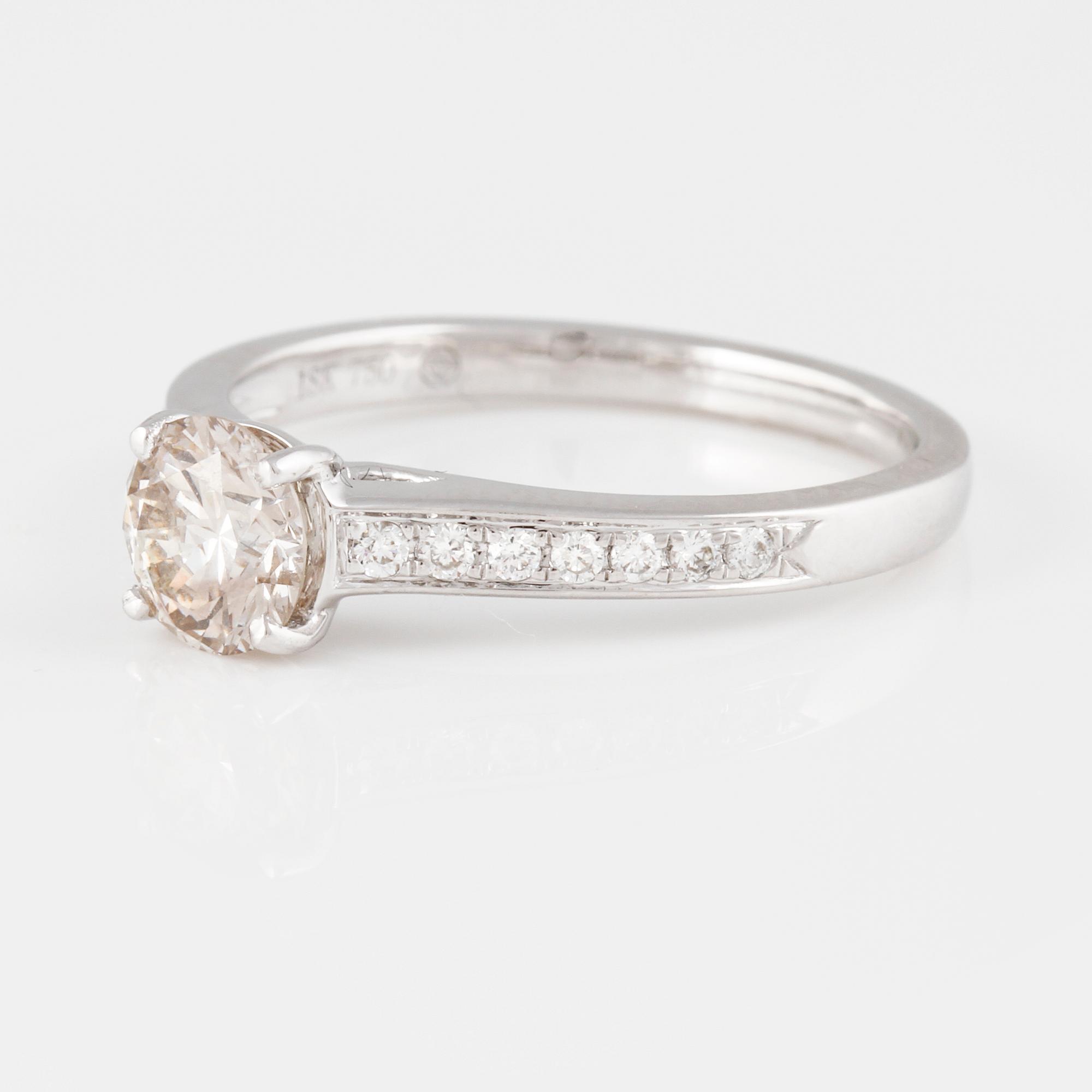 RING, 18K vitguld med briljantslipad diamant ca 0.70 ct samt små briljantslipade diamanter ca 0.10 ct. Vikt 2,9 gram.