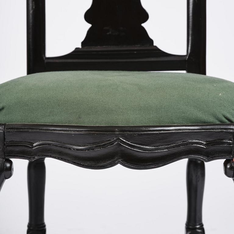 A set of eight black Swedish rococo chairs.