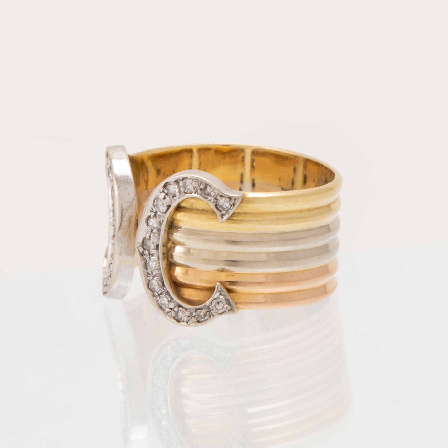 A Cartier "Double C" ring 18K tricolor gold set with round single-cut diamonds.