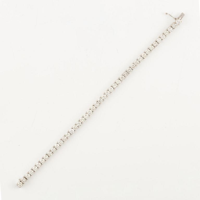 An 18K white gold tennis bracelet set with round brilliant-cut diamonds.