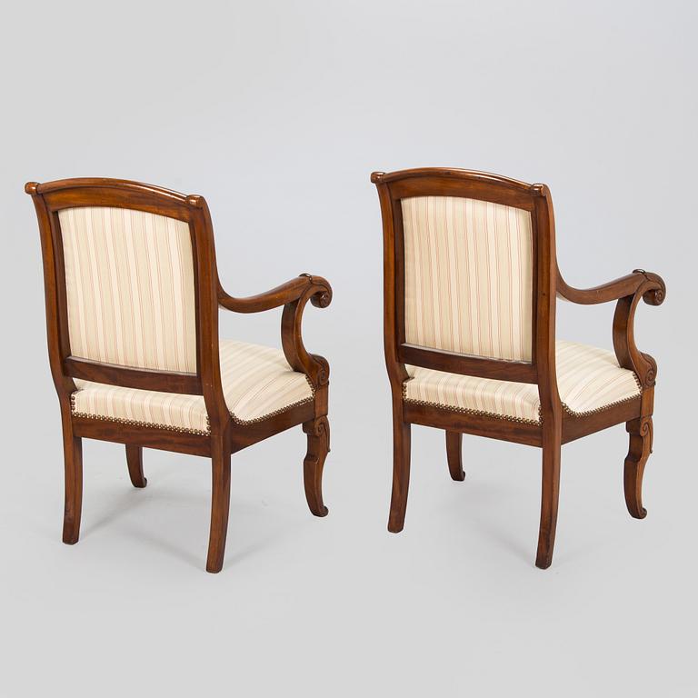 A pair of French open-arm chairs, first half of the 19th century.