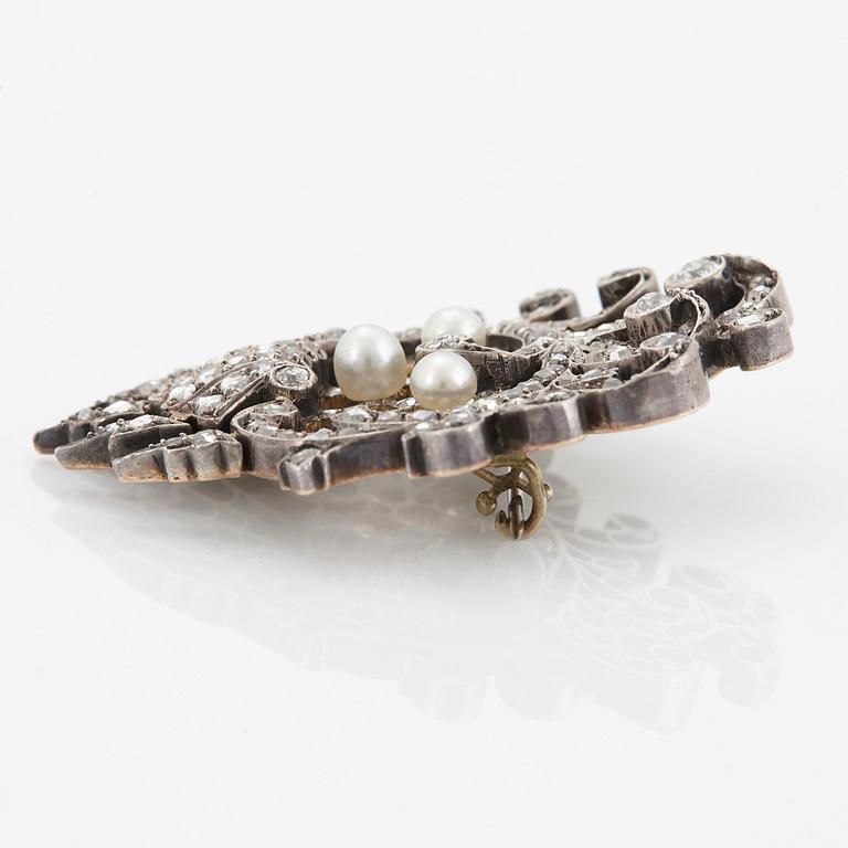 An 18K gold and silver brooch set with old- and rose-cut diamonds.
