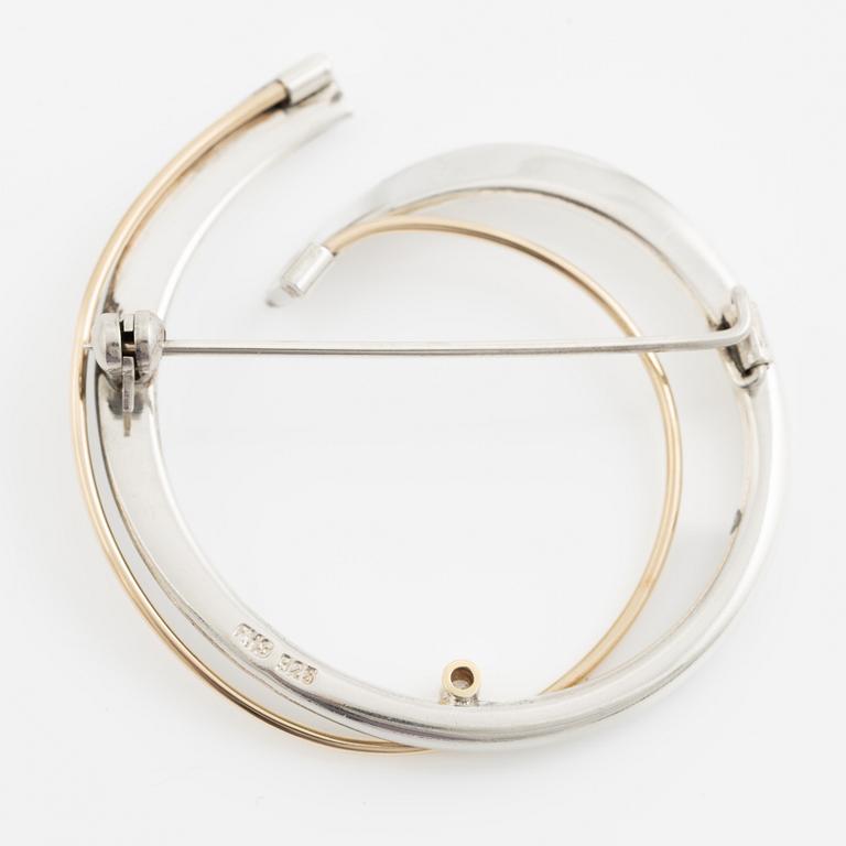 Brosch silver med en rund briljantslipad diamant.