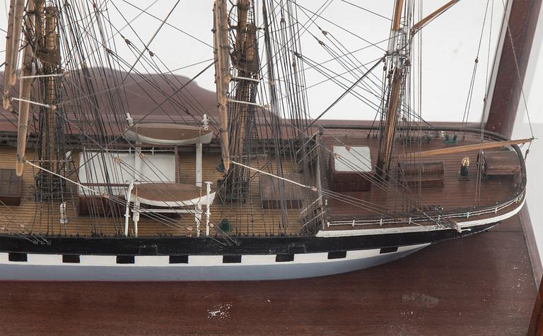 A model of a sailing ship with four masts in a glass and mahogany box by Gustav Sixten Wiman, 20th century.