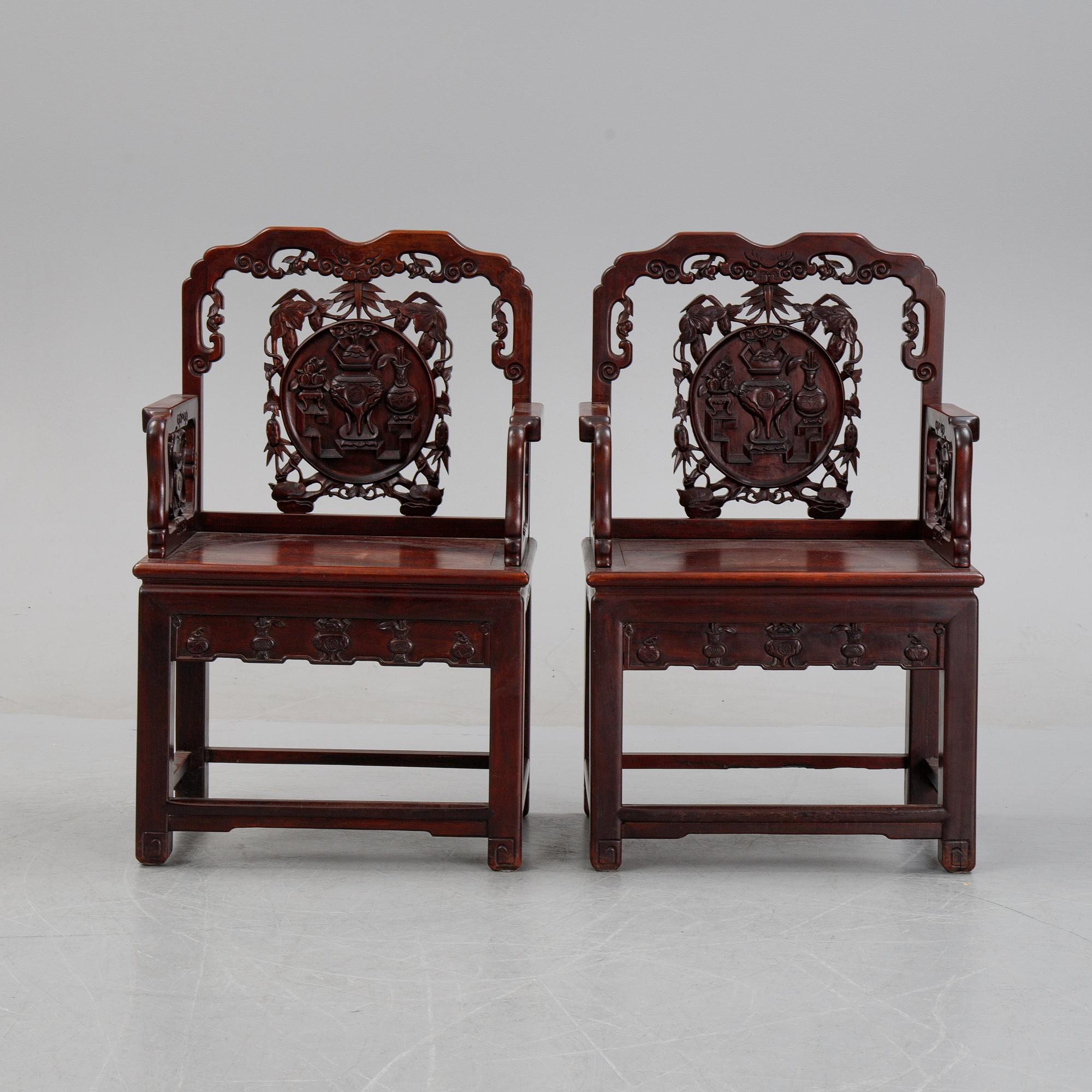 A pair of Chinese hardwood armchairs, presumably late Qing dynasty 19th century.