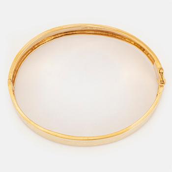 An 18K gold bangle.