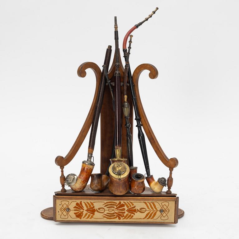 A pipestand and four pipes, circa 1900.