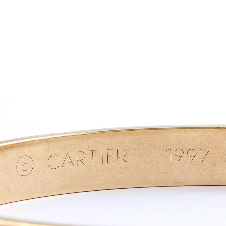 ARMRING, 18k guld besatt med diamant, ca 0,05 ct. Cartier. Vikt ca 39 g.