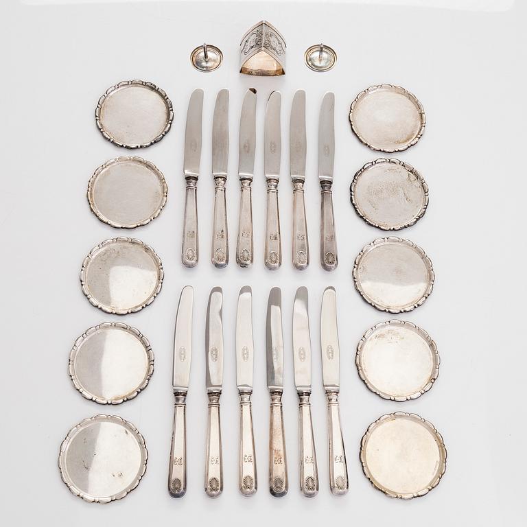 Ten silver glass coasters, 12 fruit knives, a napkin ring and a pair of cheese buttons, first half of the 20th century.