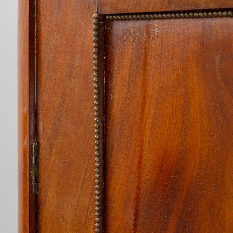 A mahogany veneered Empire cupboard, first half of the 19th century.