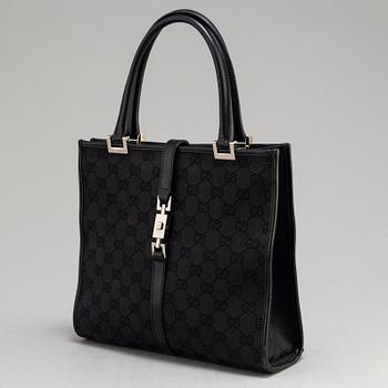 GUCCI, a leather and canvas bag.