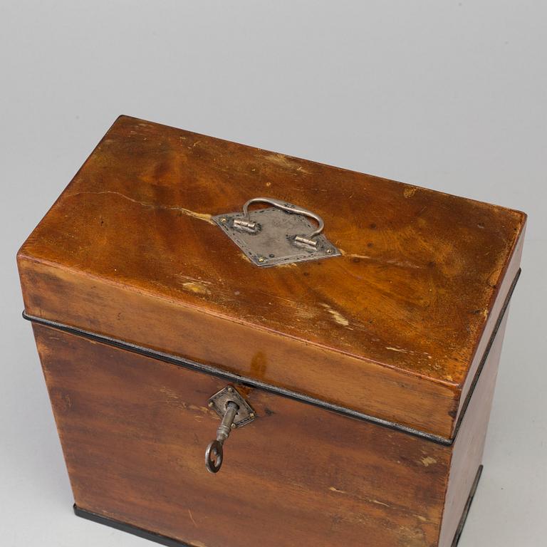 A mid 19th century mahogany veneered box with three glass bottles.