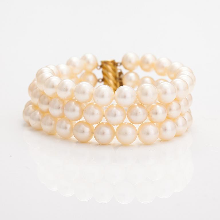 A three-strand pearl bracelet with cultured pearls and a 14K gold clasp.