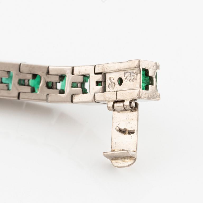 An 18K white gold bracelet with step-cut emeralds.