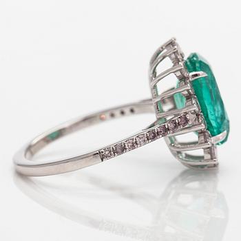 A 14K white gold ring, with an oval-cut emerald and diamonds. With IGI certificate.