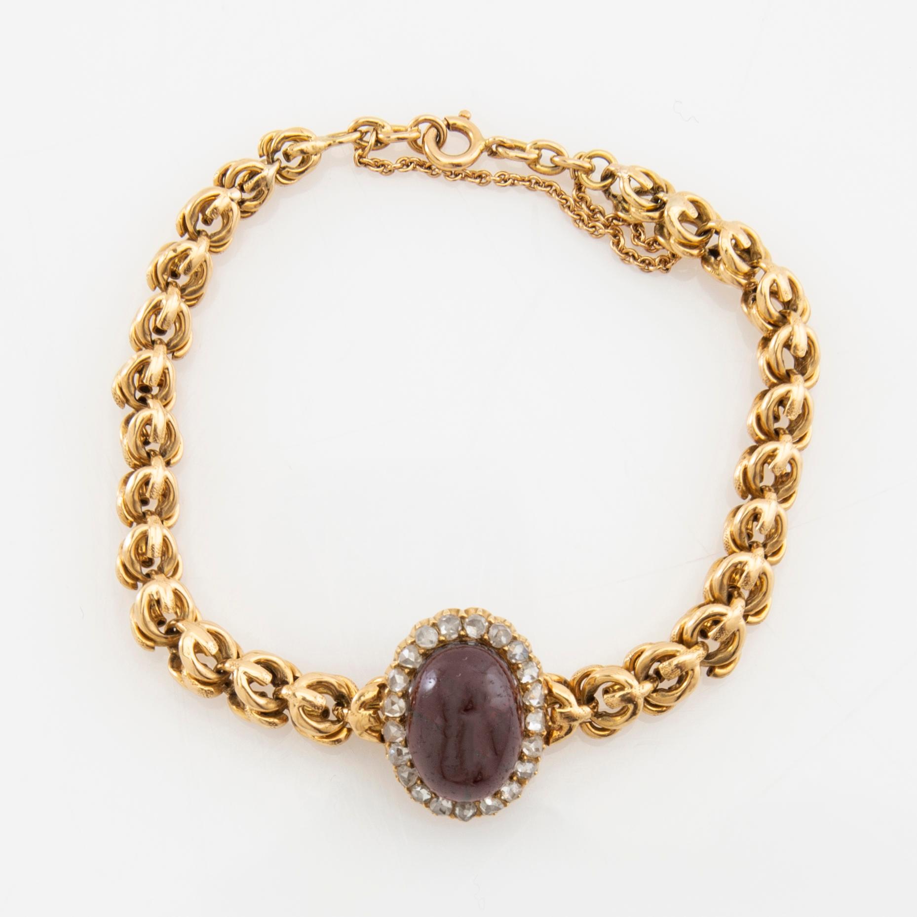 Bracelet in 18K gold set with rose-cut diamonds and an oval cabochon-cut garnet.