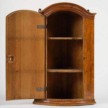 A Swedish late baroqu elm-veneered corner hanging cabinet. first part 18th century.