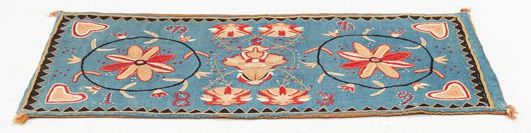 An embroidered carrige cushion, c. 92 x 44 cm, Scania, Sweden, signed BD and dated 1839.