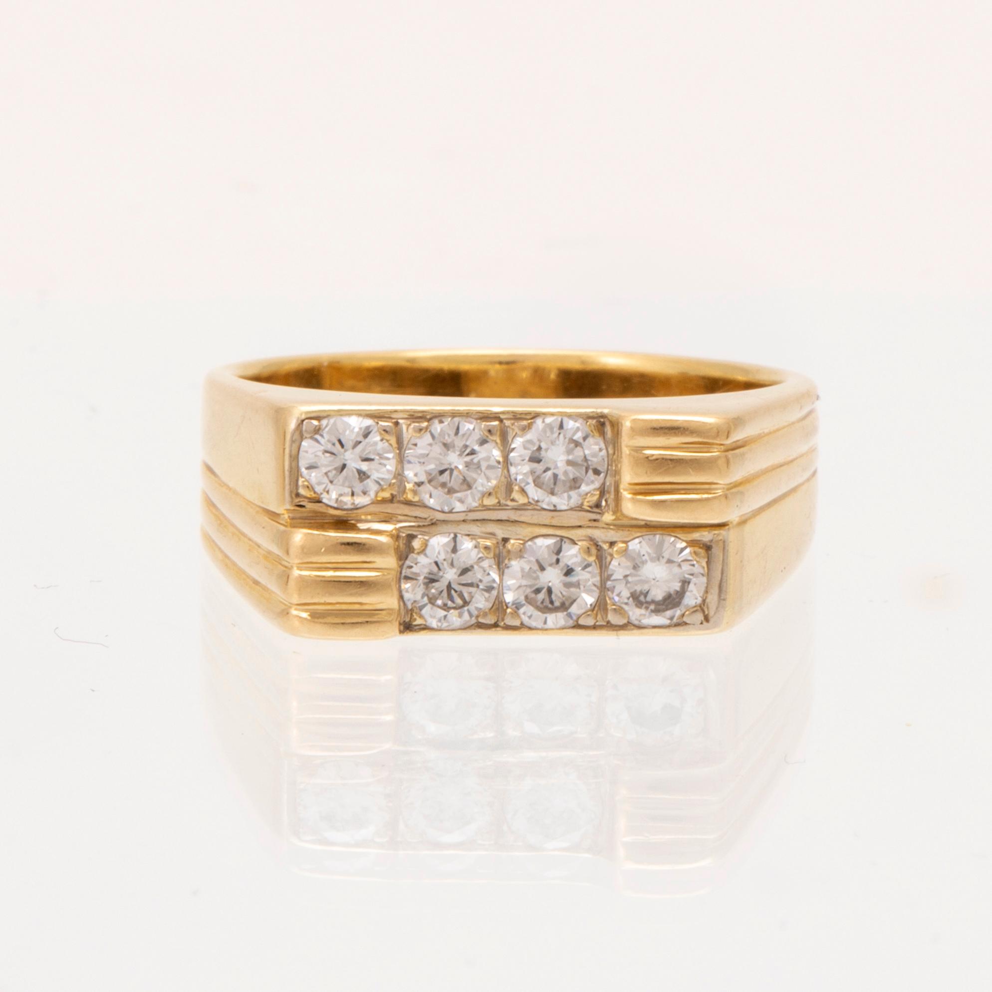 An 18K gold ring set with round brilliant cut diamonds.
