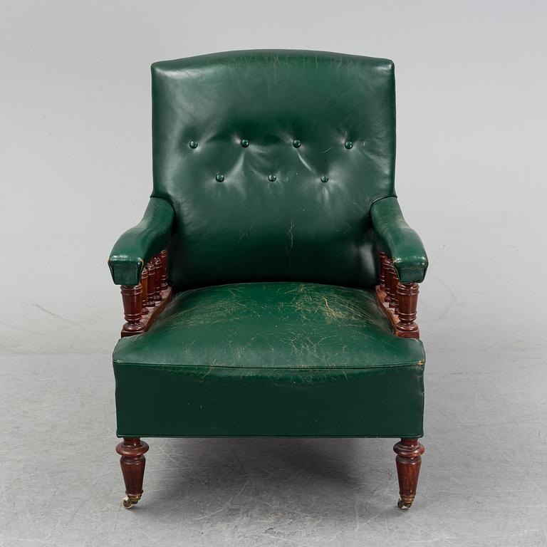 An early 20th Century easy chair with leather upholstery.