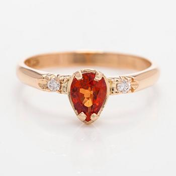 A 14K gold ring, with a pear-cut orange sapphire and diamonds.