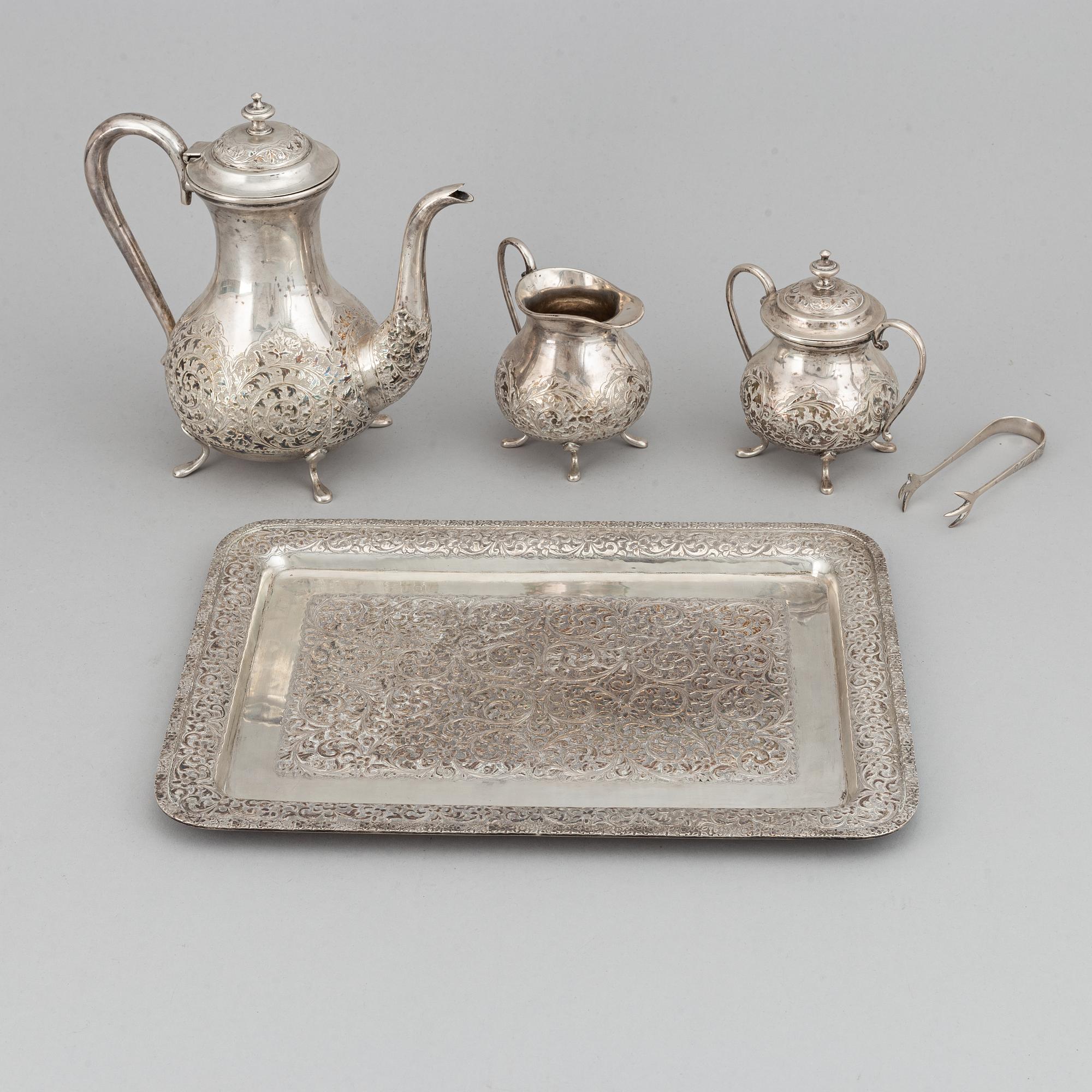 A Pakistan silver coffee pot, sugar bowl, sugar tongs and creamer.