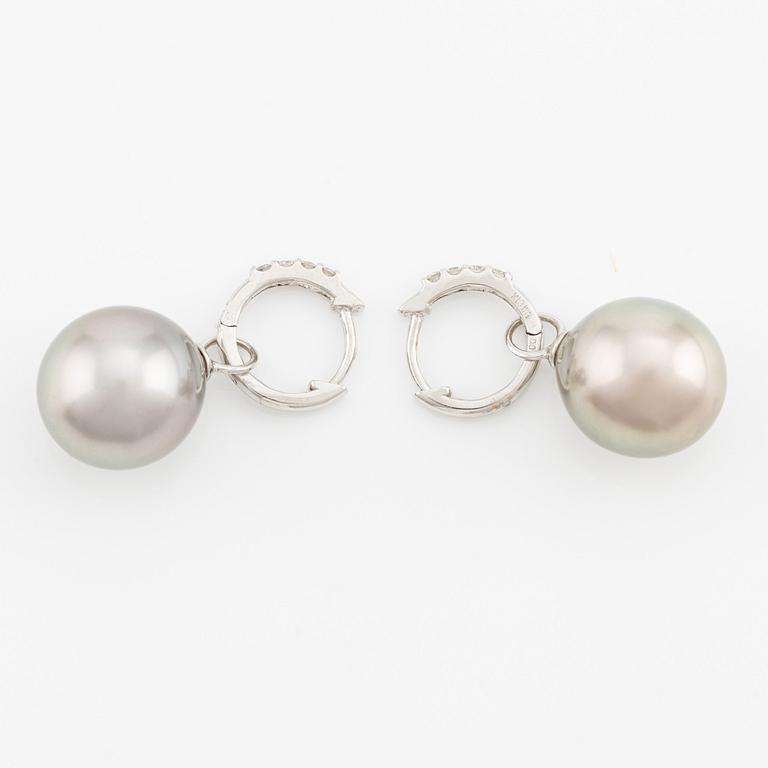 A pair of 18K gold earrings with cultured Tahitian pearls and round brilliant-cut diamonds.