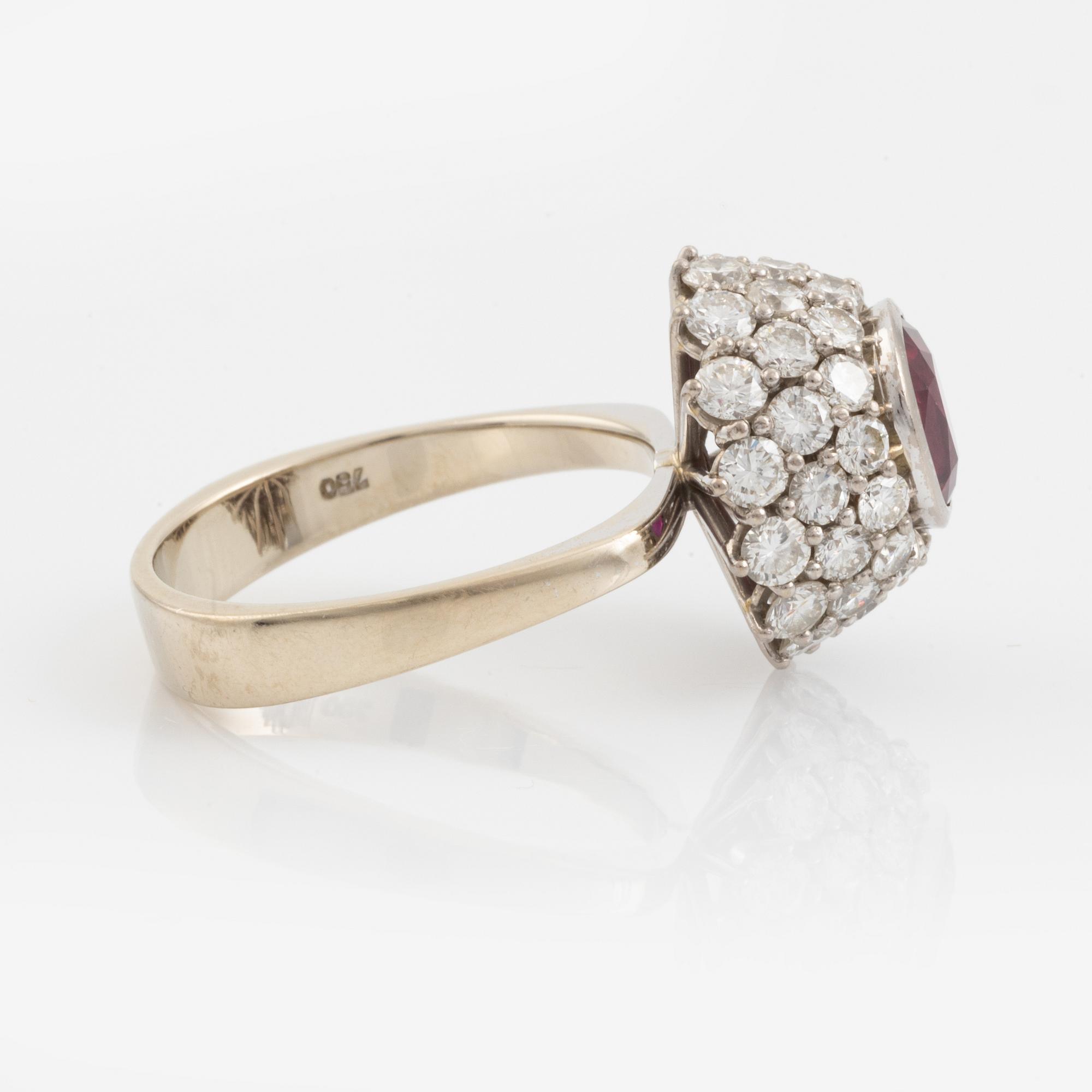 Ring 18K guld med en fasettslipad rubin samt runda briljantslipade diamanter.