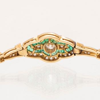 An 18K white and red gold bracelet set with emeralds between rose cut and old cut diamonds.