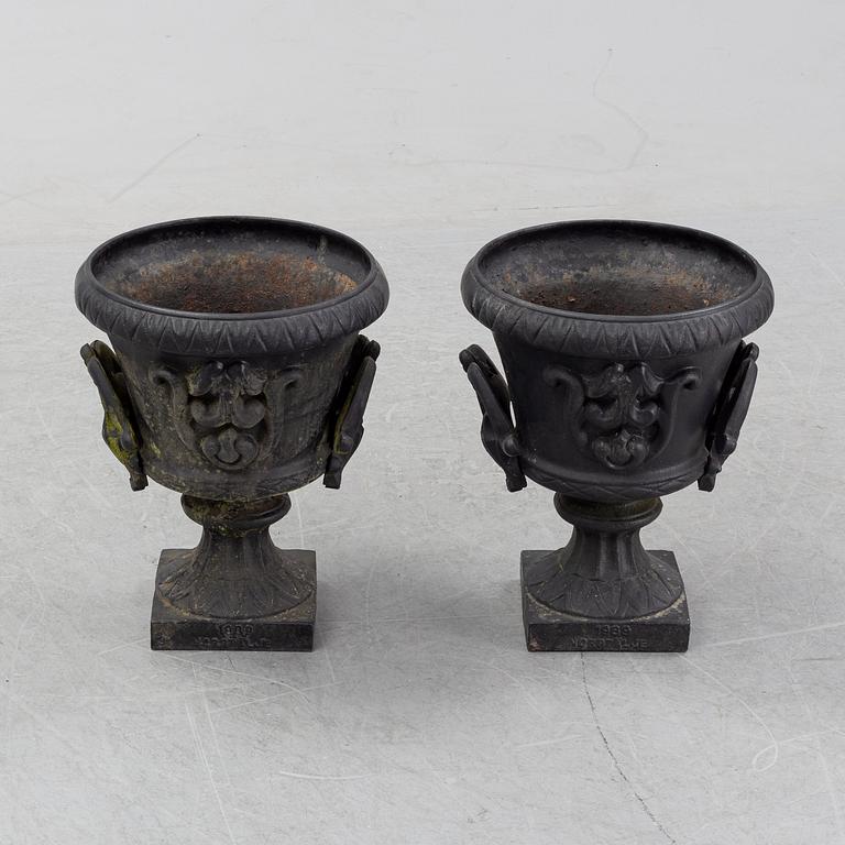 A pair of cast iron garden urns, Norrtälje dated 1989.