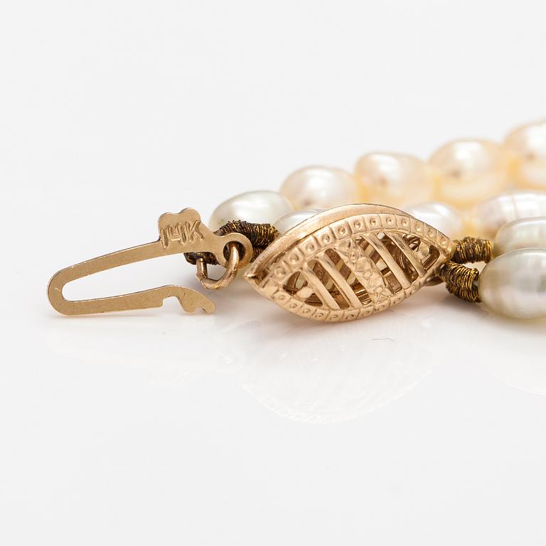 A two-strand pearl collier with cultured pearls and 14K gold clasp.